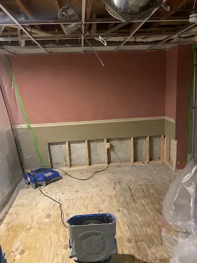 Flood-cut walls and a dehumidifier drying a Waltham room down to the subfloor