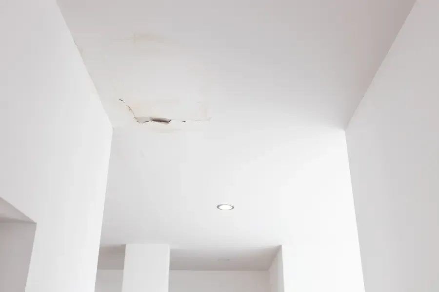 Rust-tinted stains and hairline cracks along a white ceiling soffit