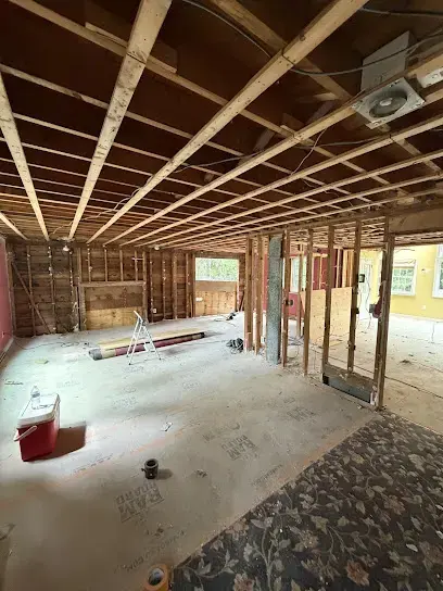 Stripped lower-level room in a Weston house with ceiling joists exposed